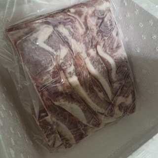진공 포장된 행복미트 통오겹살 수입산이 도마 위에 올려져 있습니다.